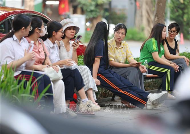 Người thân động viên thí sinh vững tin, làm tốt bài thi. Ảnh: Thanh Tùng - TTXVN